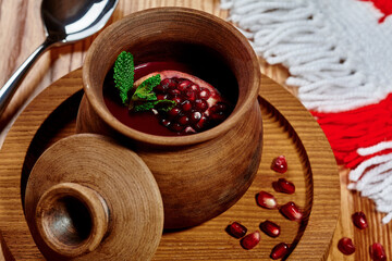 Sweet and sour pomegranate sauce in clay pot in Georgian restaurant