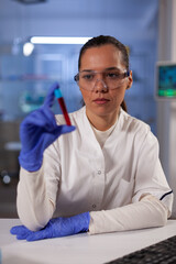Scientific research doctor holding test tube with blood for modern treatment analysis in biochemistry laboratory. Woman working at healthcare development clinic for medical innovation