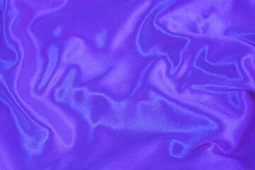 Rippled purple silk fabric background. Closeup of purple drapery cloth or satin, luxury and elegant violet texture 