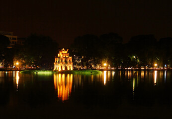 Fototapeta na wymiar Beautiful scenic view of Sword Lake and Temple Of Literature's island at night time in Old Hanoi, North Vietnam, Indochina