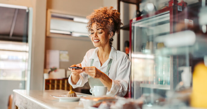 Female business owner taking a picture of her food in her cafe