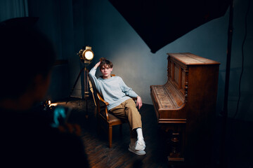 Fototapeta na wymiar guy sitting on a chair next to the piano posing photo