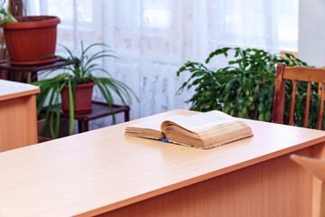 An open book on a wooden table. Selective focus