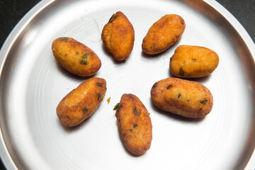 Fried crispy koftas served in a plate, an Indian vegetarian food Malai Kofta being prepared by deep frying corn balls stuffed with meshed potatoes and paneer and topped up with rich creamy gravy or cu