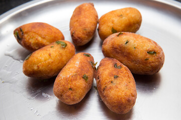 Fried crispy koftas served in a plate, an Indian vegetarian food Malai Kofta being prepared by deep frying corn balls stuffed with meshed potatoes and paneer and topped up with rich creamy gravy or cu
