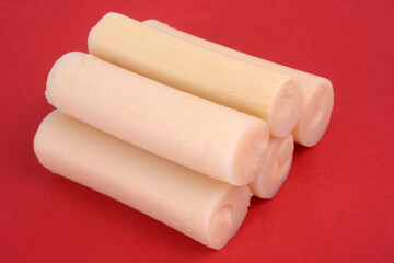 Cœurs de palmier empilés en gros plan sur fond rouge