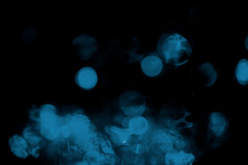 Blue  glitter bokeh against dark background.