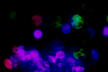 Abstract glitter bokeh of multi coloured with light effects on dark background.	