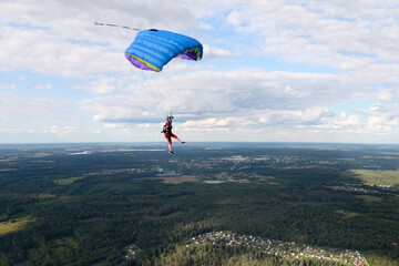 Skydiving. A girl is piloting a parachute in the sky.