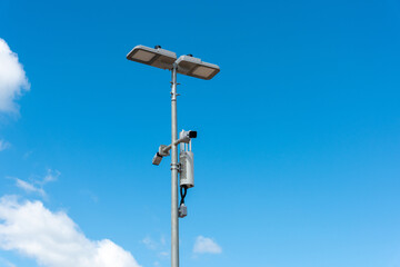 CCTV camera with blue sky background. Close-up of outdoor surveillance cameras on a street pole, Ensuring security on the street..