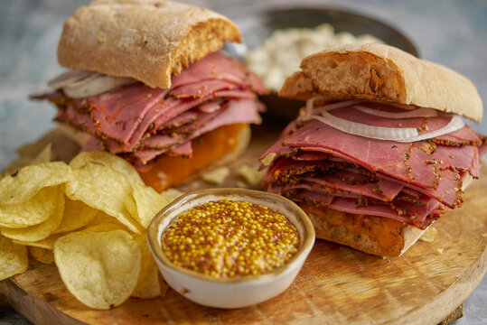 Pastrami sandwhich with delicious meet on baguette bread with chedder cheese, onion