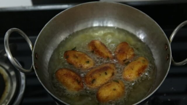 Cooking an Indian vegetarian dish  malai kofta  being prepared by deep frying corn balls stuffed with meshed potatoes and paneer and topped up with rich creamy gravy or curry