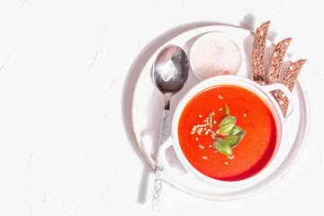 Red puree soup with tomato, greens, and bread