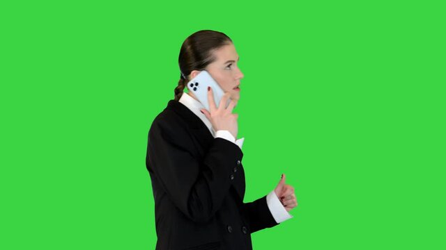 Young female office worker talking on mobile phone, smiling on a Green Screen, Chroma Key.