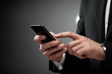 Close up of man in suit using smart phone