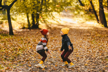Happy funny children friends brother and sister in warm bright clothes walking having fun catching...