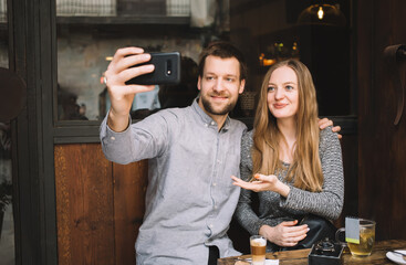 Content couple taking selfie in cafe