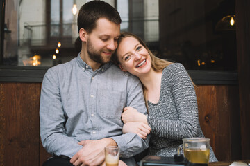 Cheerful couple hugging in cafe