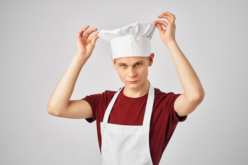 male chef with a cap on his head kitchen professionals light background