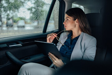 Adult woman, thinking about her job, in the car.