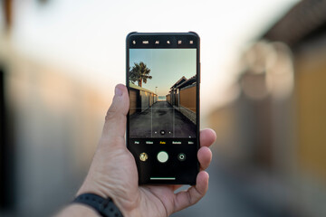 Smartphone con la cámara enseñando calle de pueblo costero