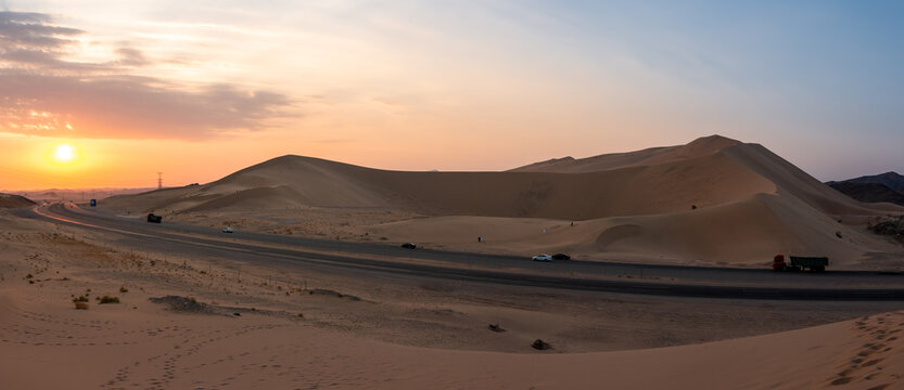 Sand dunes in Badr, Madinah, Saudi Arabia at sunset with the highway running through them