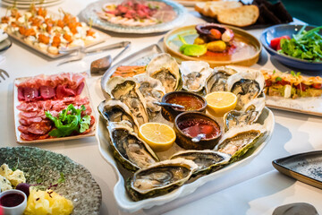 Fresh Oysters close-up. served table, lemon and ice. Healthy seafood. Fresh Oyster dinner in restaurant. Gourmet food