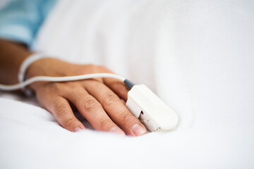 Closeup of hand with finger pulse oximeter