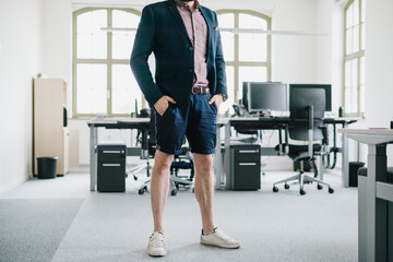 person in the office standing for desk in Shorts and blazzer