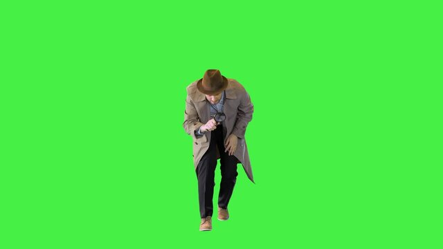 Vintage private detective on investigation use magnifier glass to examine crime scene and evidence on a Green Screen, Chroma Key.