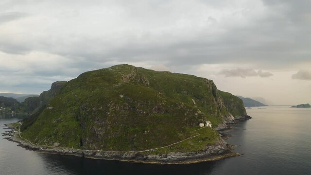 Aerial View Of Hendanes Lighthouse On The Elevated Shore Of The Island Of Vagsoy In Norway. orbiting shot