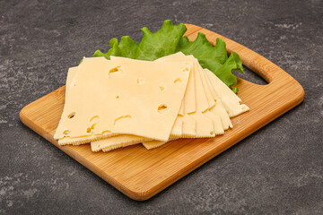Sliced yellow cheese over board
