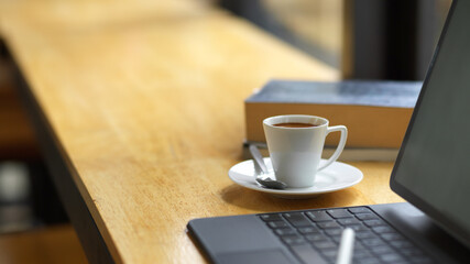 Co-working space concept, laptop with coffee cup and copy space