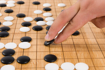 close up of player hand make a move in Go game(Weiqi),Traditional asian strategy board game