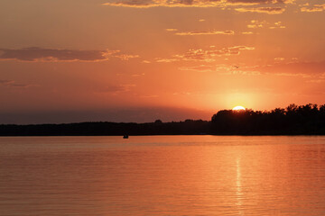 Red sunset on the river. Evening. The rays of the sun in the clouds