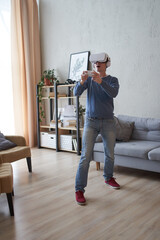 Man with virtual reality headset is playing game.