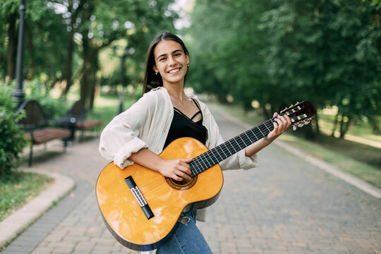 A girl musician plays the guitar in the park. Music, musician, guitar, freedom