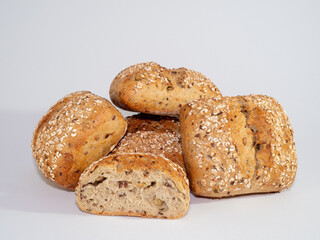 Baked bun soaked in sesame seeds and oatmeal isolated on white background. 