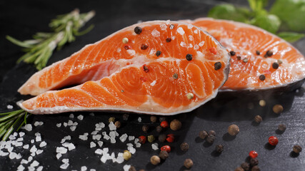 Salmon. Raw Trout Red Fish Steak with Herbs and Lemon and olive oil rotated on slate. Cooking Salmon, sea food. Healthy eating concept.