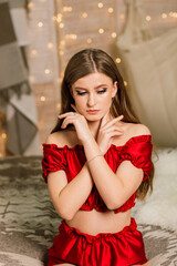 Beautiful young woman celebrating christmas at home, having fun while opening presents