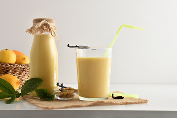 Milk drink with vanilla in containers on white kitchen bench