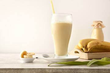 Milkshake with banana in glass cup on table kitchen isolated