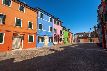 Fototapeta na wymiar Old small beautiful multi colored houses (bright colors) in Burano island in a sunny spring day. Venetian lagoon, Venice, UNESCO world heritage site, Veneto, Italy, southern Europe.