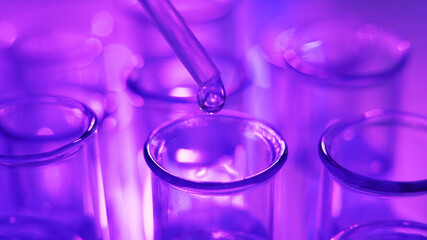 A scientist is conducting an experiment. Using a pipette, drop the reagent into the sample tube....