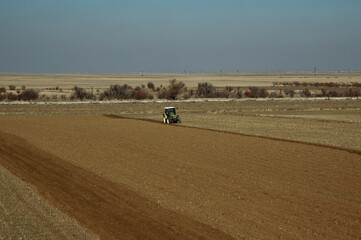 Obraz premium photo of green tractor plowing the field