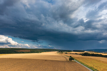 Bird's eye view of fields in the Taunus / Germany under dark, threatening clouds 