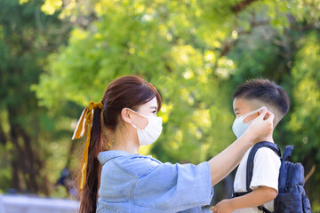 Mother help her son wearing medical mask for protection