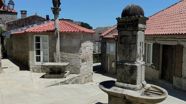 Estrechas calles peatonales con fuente y cruz de piedra en la villa de Combarro, Espa&ntilde;a