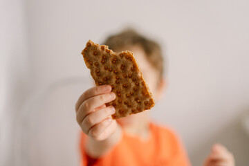 Cute little boy eats crispbread. Healthy lifestyle and nutrition concept. © Анастасія Стягайло