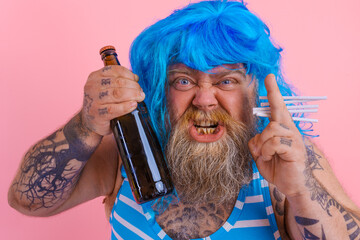 Fat man with beard and wig smokes cigarettes and drinks beer